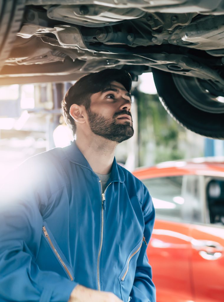 Mechanic looking under a vehicle - MOT Mossley