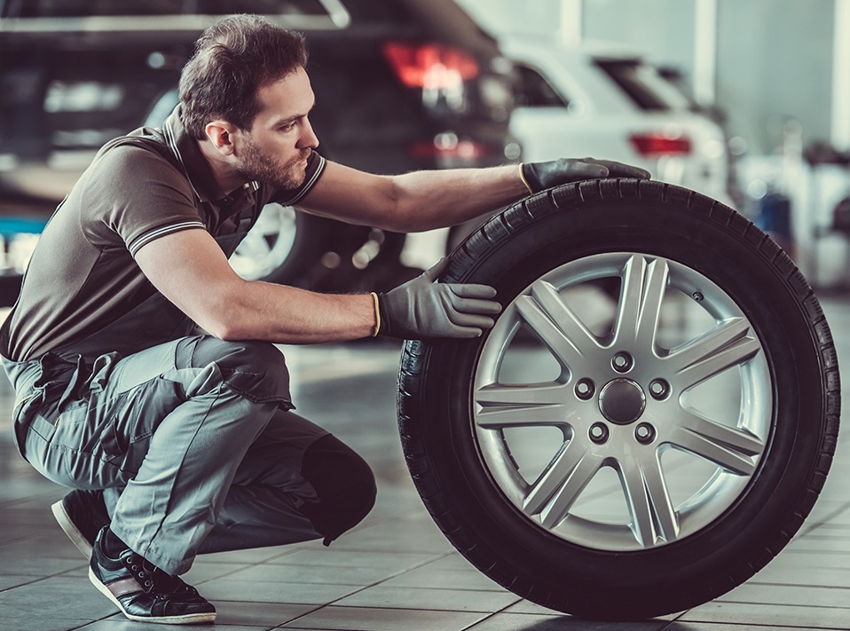 Mechanic holding a tyre - Tyres Mossley